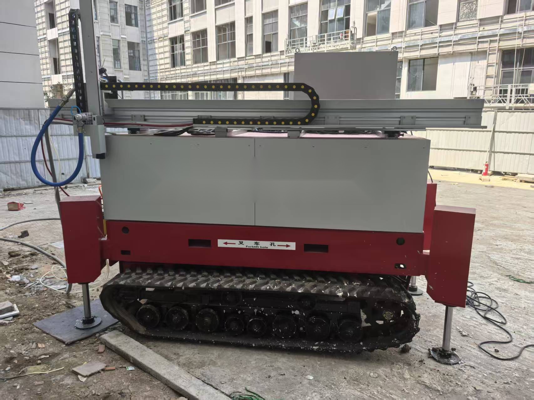 Tracked facade lifting painting robot with vertical spray mast on a building facade